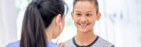 Doctor examining teenage patient with stethoscope